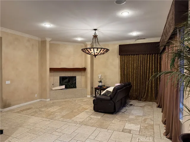 a living room with furniture a chandelier and a fireplace