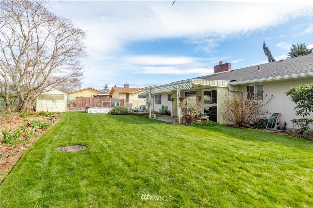 1710 Southwest Gails Avenue Chehalis, WA 98532 - Photo 4 of 24 a view of a white house with a big yard plants and large trees