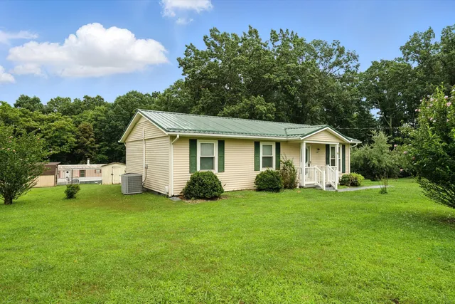 a view of a house with a yard and deck