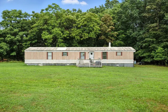 a view of a tiny house with a garden and deck