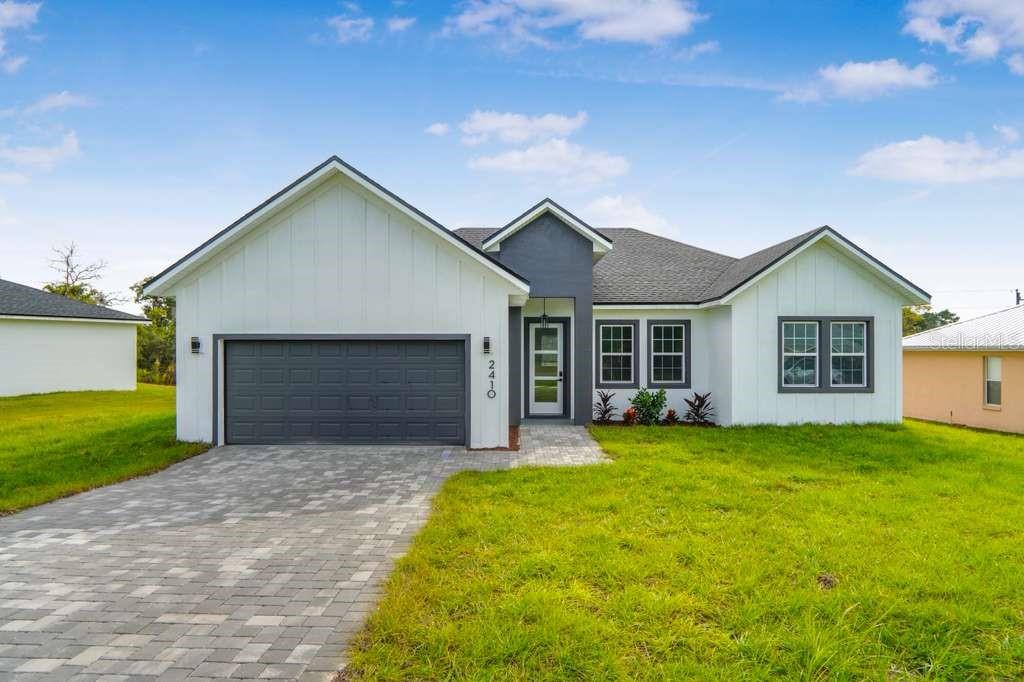 a front view of a house with yard and garage