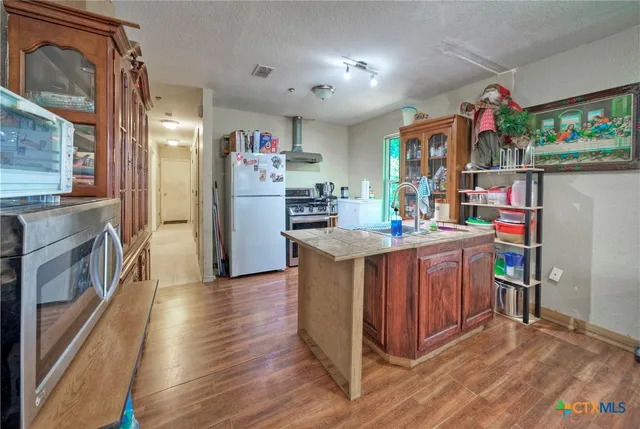 a kitchen that has a lot of cabinets a sink and a stove in it