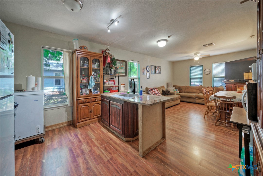 604 Vargas Road Austin, TX 78741 - Photo 15 of 25 a kitchen with stainless steel appliances kitchen island wooden floors and view living room