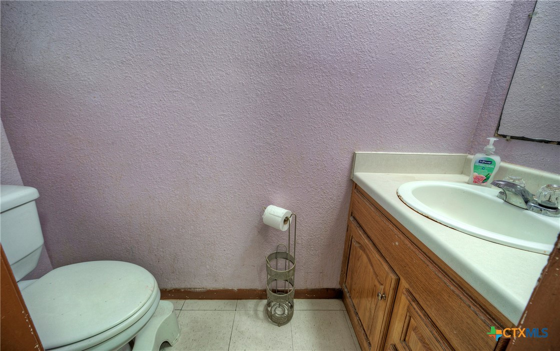 604 Vargas Road Austin, TX 78741 - Photo 24 of 25 a bathroom with a granite countertop toilet and a sink