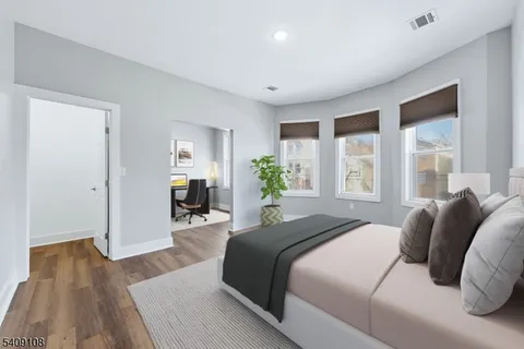 a bedroom with a bed wooden floor and window