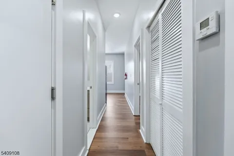 a view of a hallway with wooden floor and staircase