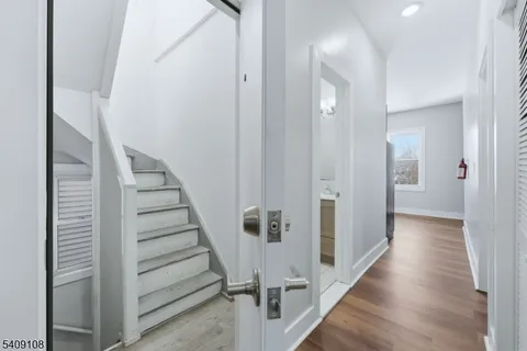 a view of a hallway with wooden floor and entryway