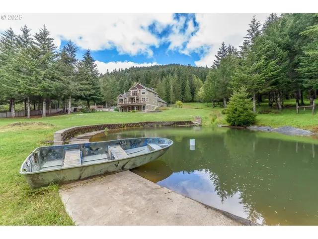a view of a lake with a yard and a large tree