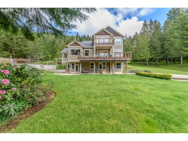 a view of a house with a big yard and large trees