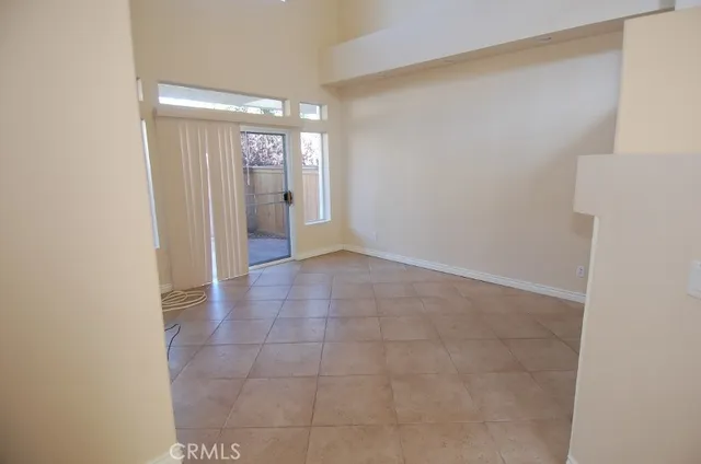a view of an empty room with window and bathroom
