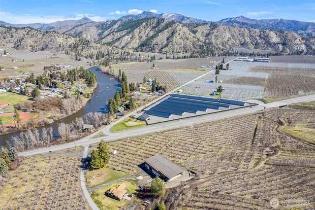 a backyard view with table and chairs under an umbrella