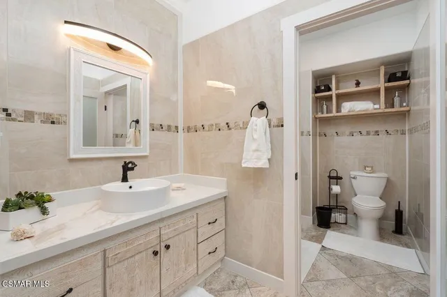 a bathroom with a sink a toilet and a mirror