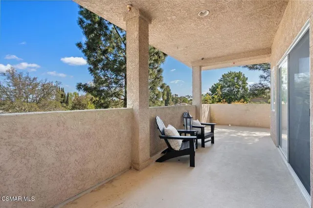 a roof deck with table and chairs and potted plants