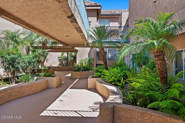 a view of a yard with plants and a table under an umbrella