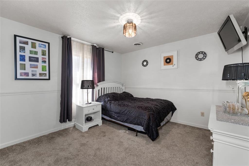 58 Cedar Bluff Winder, GA 30680 - Photo 14 of 39 a bedroom with a bed and a chandelier