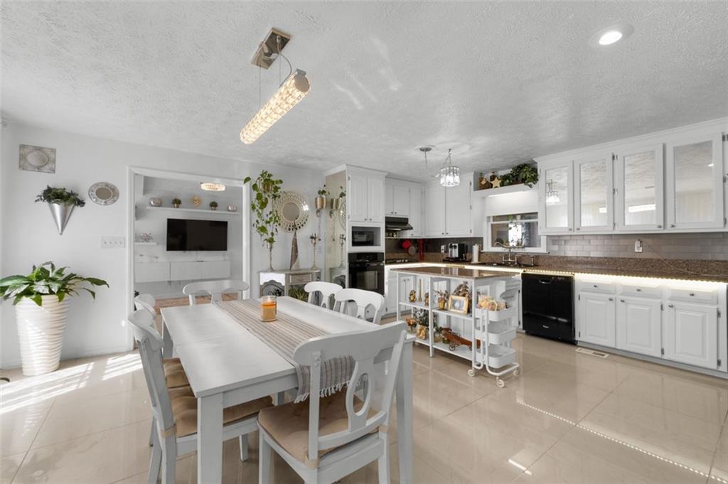 58 Cedar Bluff Winder, GA 30680 - Photo 7 of 39 a kitchen with stainless steel appliances kitchen island granite countertop a dining table chairs and white cabinets