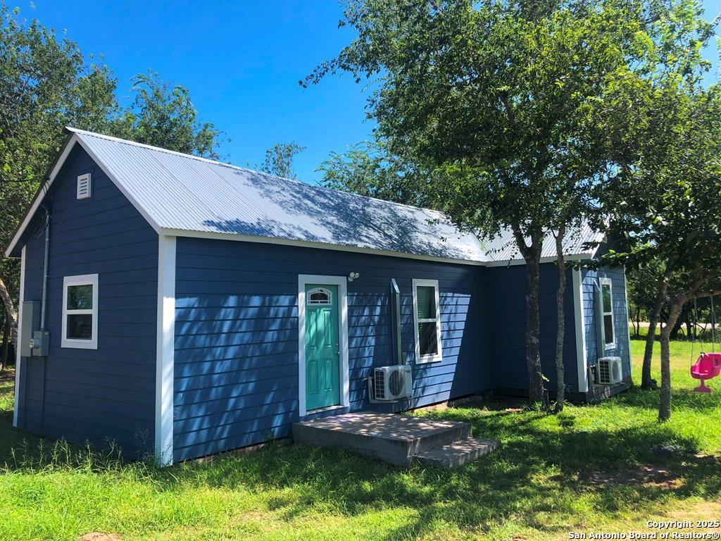 a backyard of a house with yard and outdoor seating