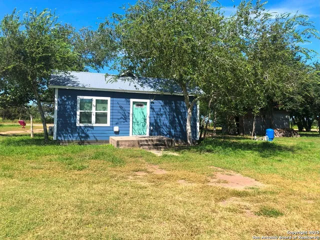 a view of a house with a yard patio and a garden