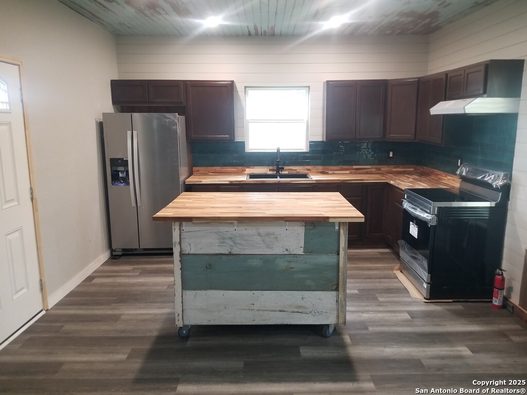443 Bee Tuleta, TX 78142 - Photo 3 of 27 a kitchen with kitchen island granite countertop wooden cabinets and a counter top space