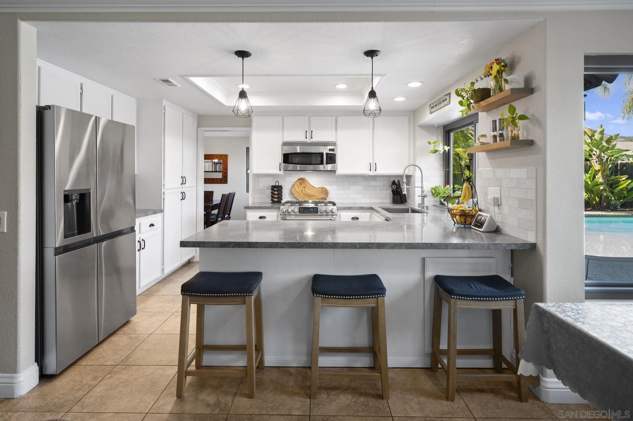 13972 Poway Valley Road Poway, CA 92064 - Photo 14 of 59 a kitchen with stainless steel appliances granite countertop a table chairs stove and refrigerator