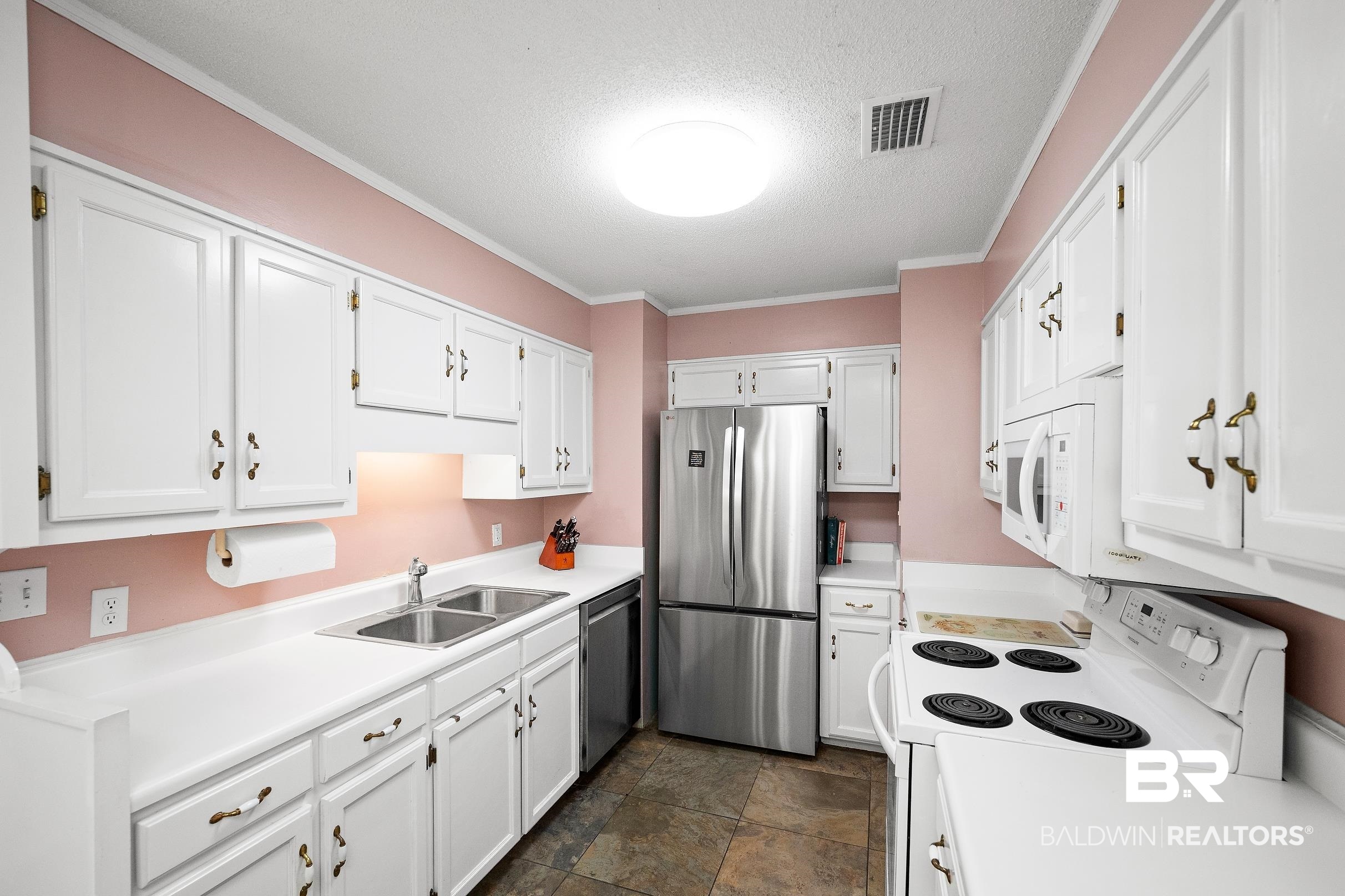 4026 Kingsrow Row Mobile, AL 36619 - Photo 11 of 51 Kitchen featuring stainless steel appliances, light countertops, white cabinets, ornamental molding, and a textured ceiling