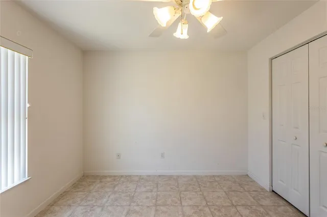 an empty room with a chandelier fan