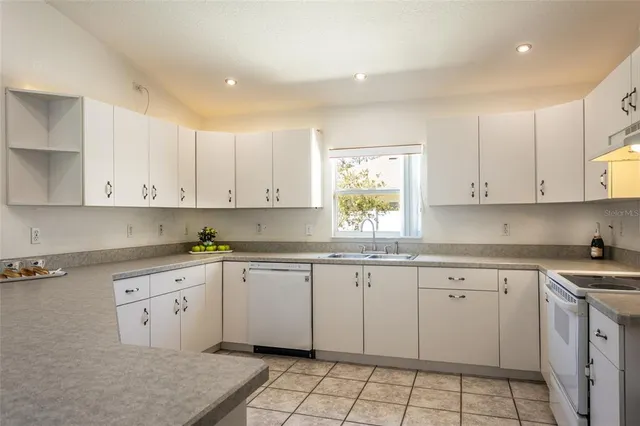 a kitchen with a sink window and cabinets