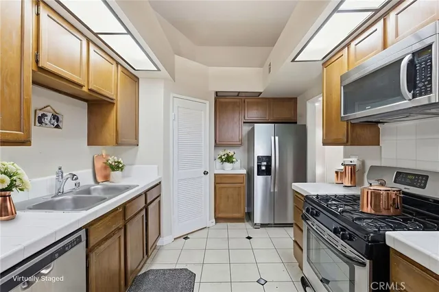 a kitchen with stainless steel appliances granite countertop a stove refrigerator and a sink