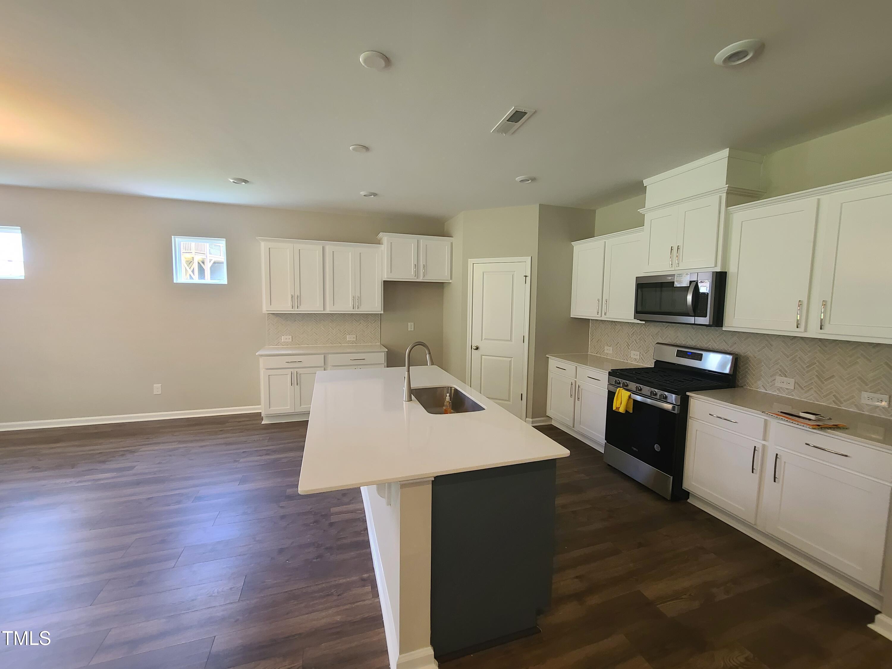 154 Black Cloud Drive Louisburg, NC 27549 - Photo 12 of 28 a kitchen with granite countertop a stove top oven a sink dishwasher and a refrigerator with wooden floor