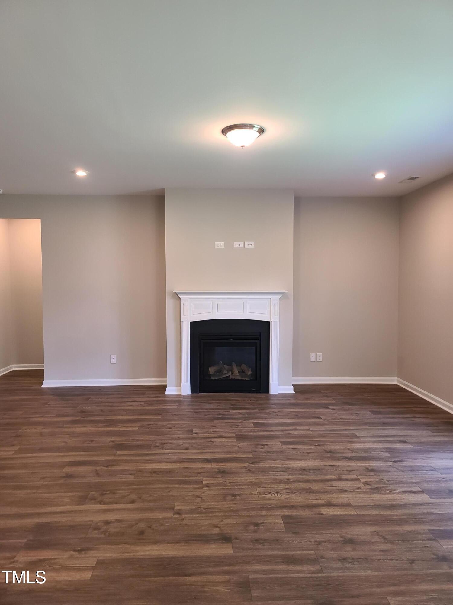 154 Black Cloud Drive Louisburg, NC 27549 - Photo 8 of 28 a view of empty room with wooden floor and fireplace