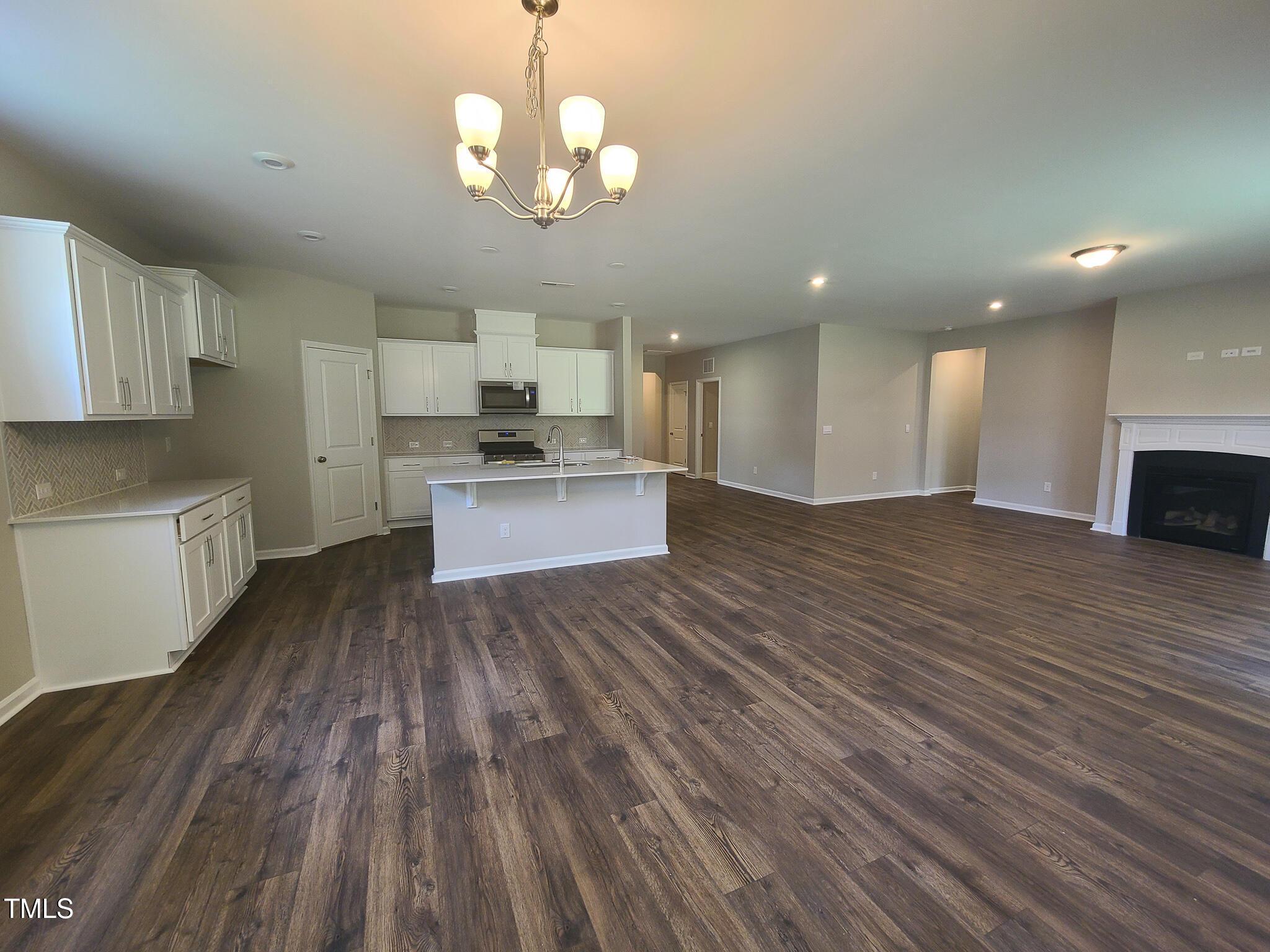 154 Black Cloud Drive Louisburg, NC 27549 - Photo 9 of 28 a view of kitchen with granite countertop wooden floor stainless steel appliances and cabinets
