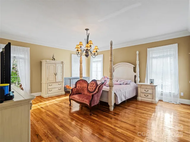 a spacious bedroom with a bed and a chandelier