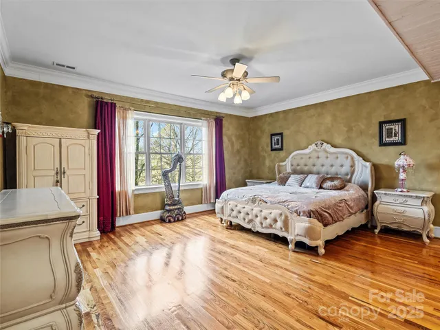 a spacious bedroom with a large bed and a chandelier