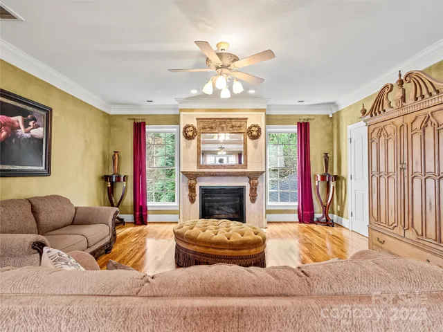 a living room with furniture a fireplace and a large window