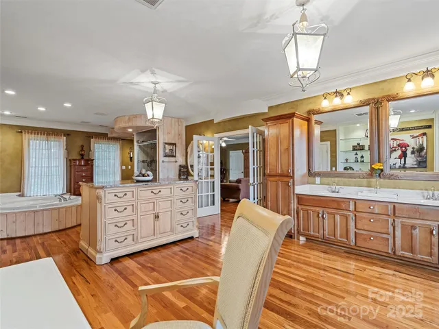 a spacious bathroom with a double vanity sink a mirror a bathtub and a shower