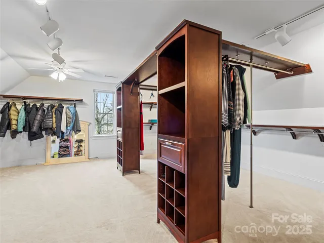 a view of walk in closet with clothes and shoes