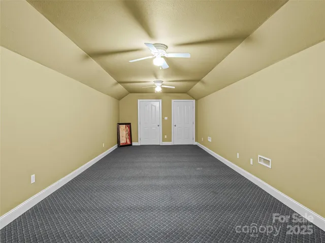 an empty room with a ceiling fan and a window