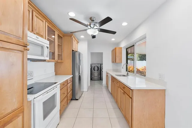 a kitchen with stainless steel appliances granite countertop a sink and dishwasher a refrigerator with wooden floor