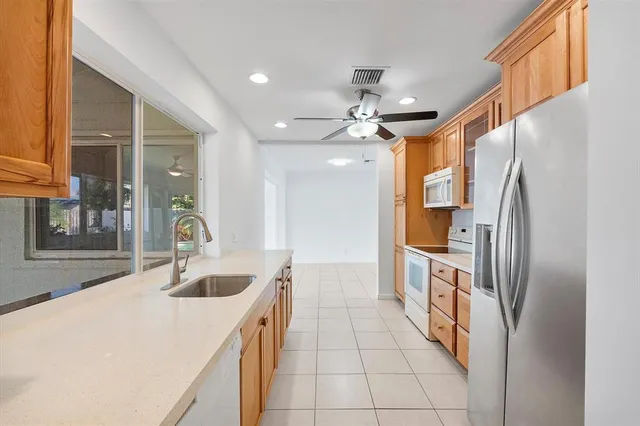 a kitchen with stainless steel appliances granite countertop a sink and a refrigerator