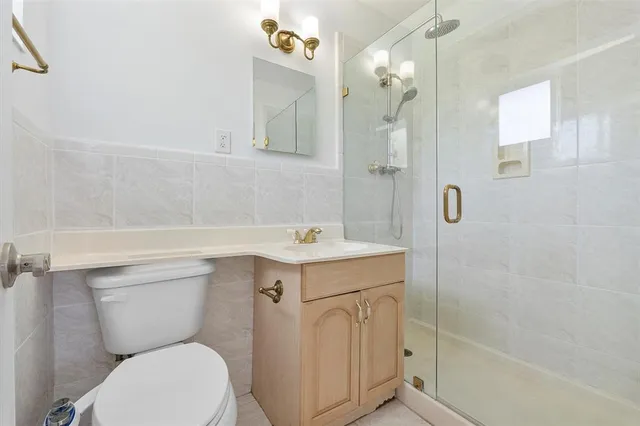 a bathroom with a sink a toilet a mirror and shower