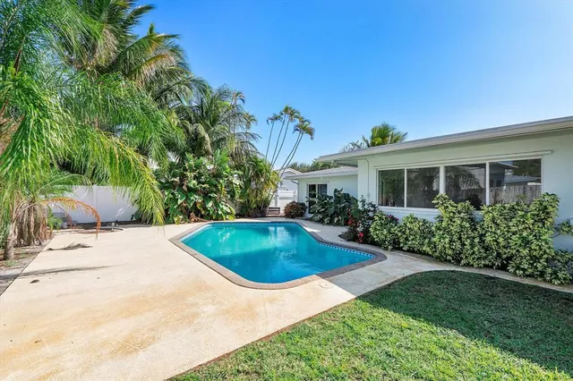 a swimming pool with outdoor seating and yard