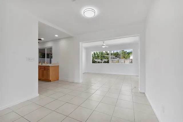 an empty room with kitchen and windows