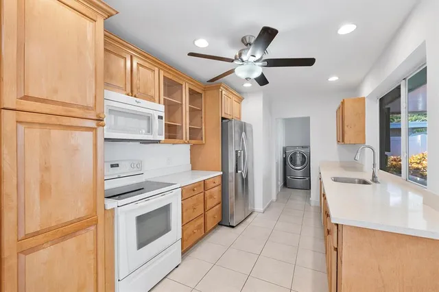 a kitchen with stainless steel appliances a stove a sink and a refrigerator