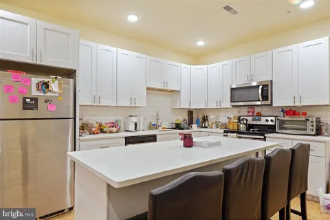 a kitchen with stainless steel appliances a stove refrigerator sink and cabinets