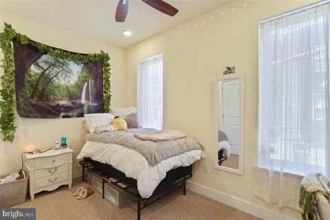 a bedroom with a bed and large windows