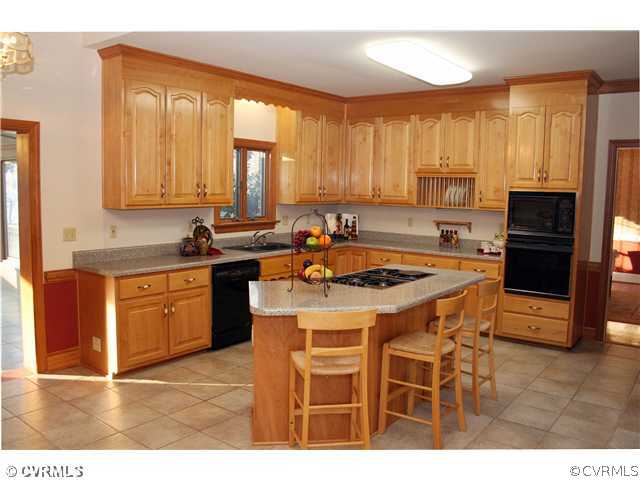12904 Rockridge Road Chester, VA 23831 - Photo 7 of 12 a kitchen with a sink stove and cabinets