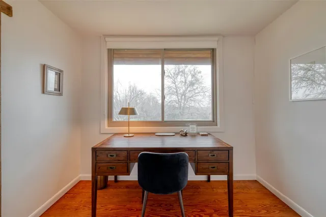 a view of a workspace with furniture and window