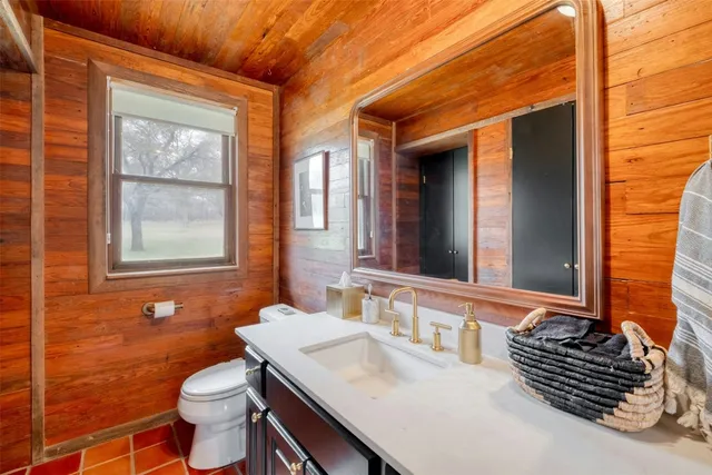 a bathroom with a granite countertop toilet a sink and a mirror