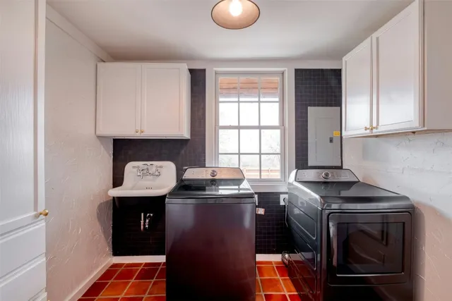 a utility room with stainless steel appliances granite countertop a sink stove and cabinets