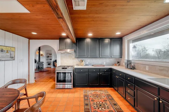 a large kitchen with stainless steel appliances granite countertop a sink and cabinets